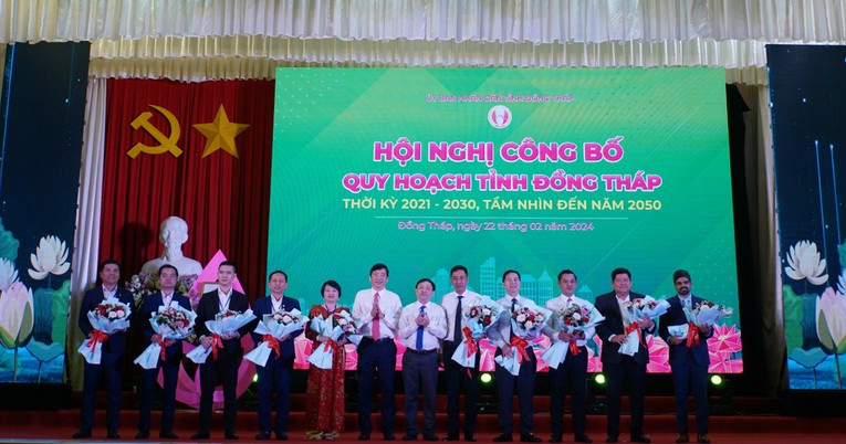 Chủ tịch UBND tỉnh Đồng Tháp cùng lãnh đạo tỉnh tặng hoa cho các doanh nghiệp, nhà đầu tư tại lễ công bố quy hoạch. Ảnh: Thụy Du