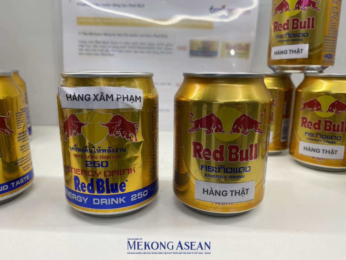 Một trong những sản phẩm hay bị “bắt chước” là nước tăng lực thương hiệu Red Bull. Khi nhìn thoáng qua, nhiều người không nhận ra đâu là hàng thật và hàng xâm phạm. Trên các lon Red Bull chính hãng, hình ảnh thiết kế con vật trên logo của các sản phẩm nhái lại hoàn toàn khác như con trâu…Hay vòng tròn màu vàng tuy không có sự thay đổi về màu sắc nhưng lại được đổi sang các hình thù khác như hình lục giác, hình oval….Ảnh: Hà Anh/Mekong ASEAN.