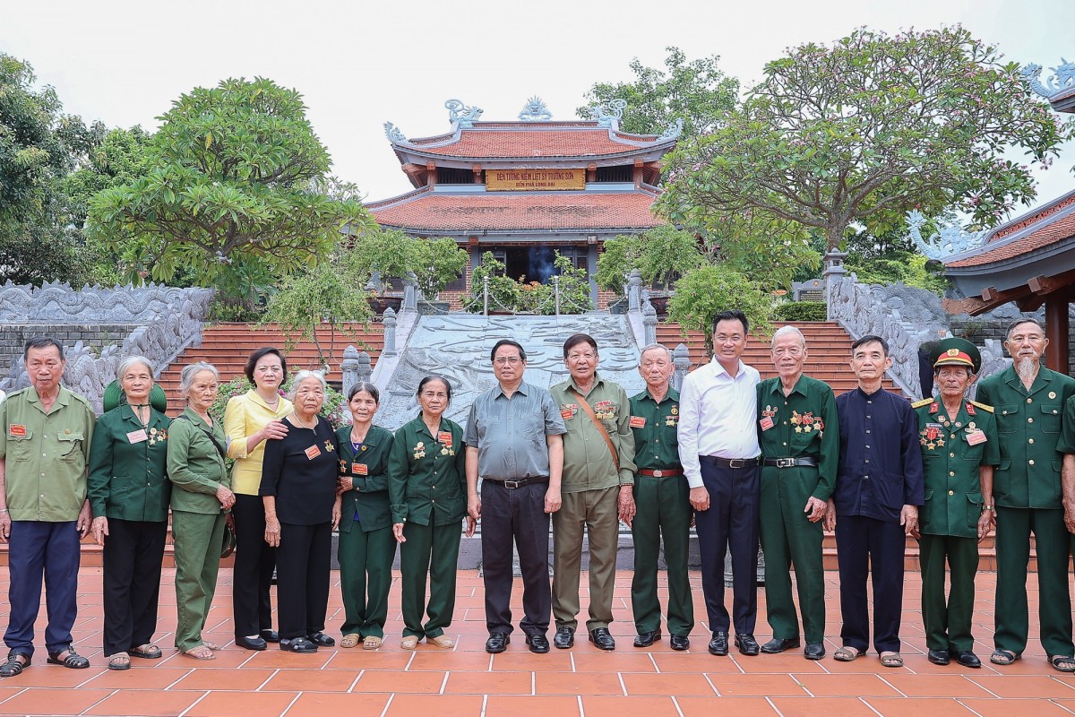 Thủ tướng chụp ảnh lưu niệm cùng các cựu chiến binh, thanh niên xung phong tại Đền tưởng niệm liệt sĩ Trường Sơn bến phà Long Đại. Ảnh: VGP.