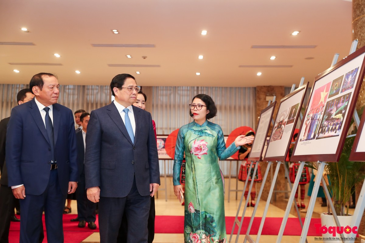 Thủ tướng Chính phủ Phạm Minh Chính và Bộ trưởng Bộ VHTTDL Nguyễn Văn Hùng, cùng các đại biểu xem nghệ nhân trình diễn trong không gian trưng bày ảnh về thành tựu của ngành VHTTDL năm 2023 - Ảnh: 