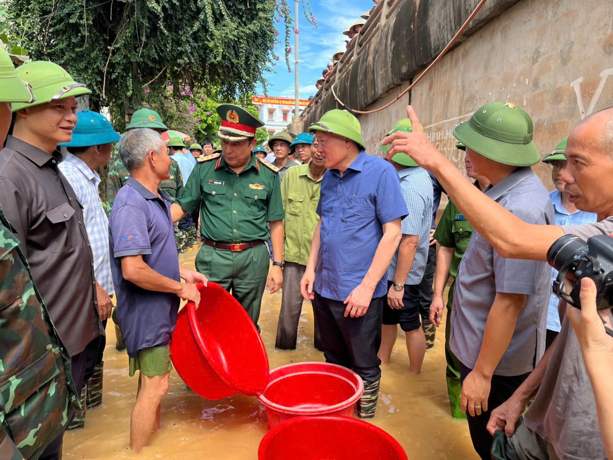 Phó Thủ tướng Thường trực Chính phủ Nguyễn Hoà Bình thăm hỏi, động viên người dân tại khu vực bị ngập lụt do vỡ đê bối tại xã Tiên Lục - Ảnh: VGP