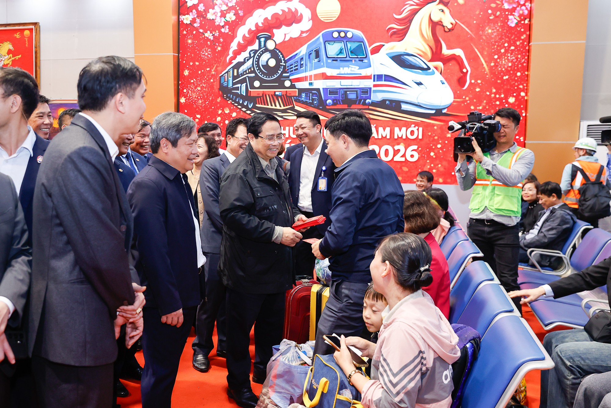 Thủ tướng mừng tuổi cho bà con, hành khách tại ga Hà Nội - Ảnh: VGP/Nhật Bắc