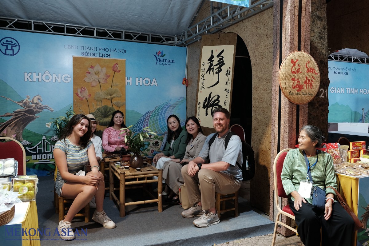 Du khách nước ngoài thưởng thức trà sen.