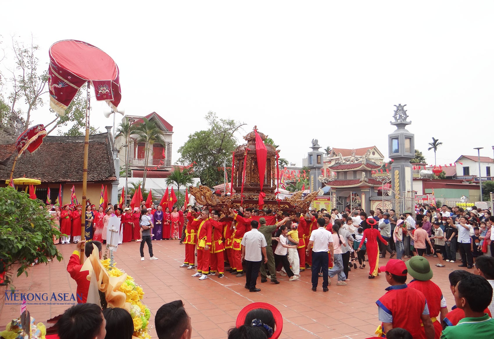 Người dân chui qua kiệu tại sân đình. Ảnh: Mekong ASEAN.