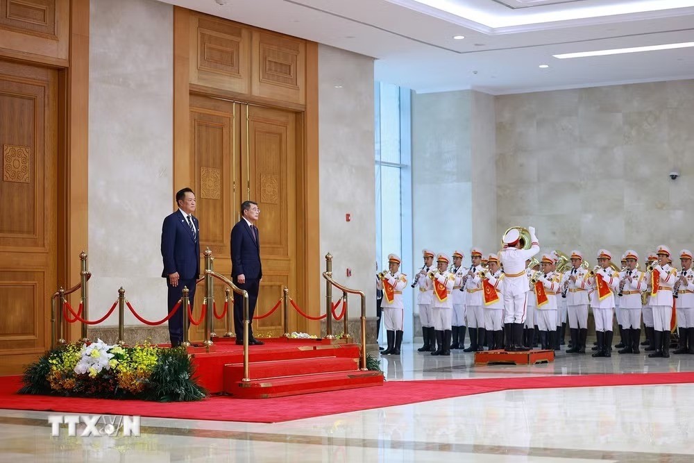 Thủ tướng Lê Minh Hưng và Thủ tướng Vương quốc Thái Lan Anutin Charnvirakul nghe quân nhạc cử Quốc thiều hai. nước. Ảnh: TTXVN.