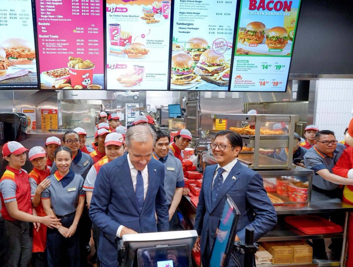 Ông Mark Carney và ông Ferdinand Marcos Jr xem thực đơn và gọi món tại cửa hàng Jollibee trên phố Granville, Vancouver, ngày 3/7. Ảnh: Facebook/@Bongbong Marcos (tài khoản Facebook của Tổng thống Philippines)