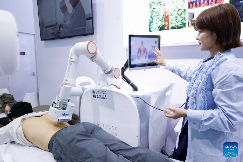 Khách tham quan trải nghiệm robot massage thông minh tại hội chợ. Ảnh: Tân Hoa xã