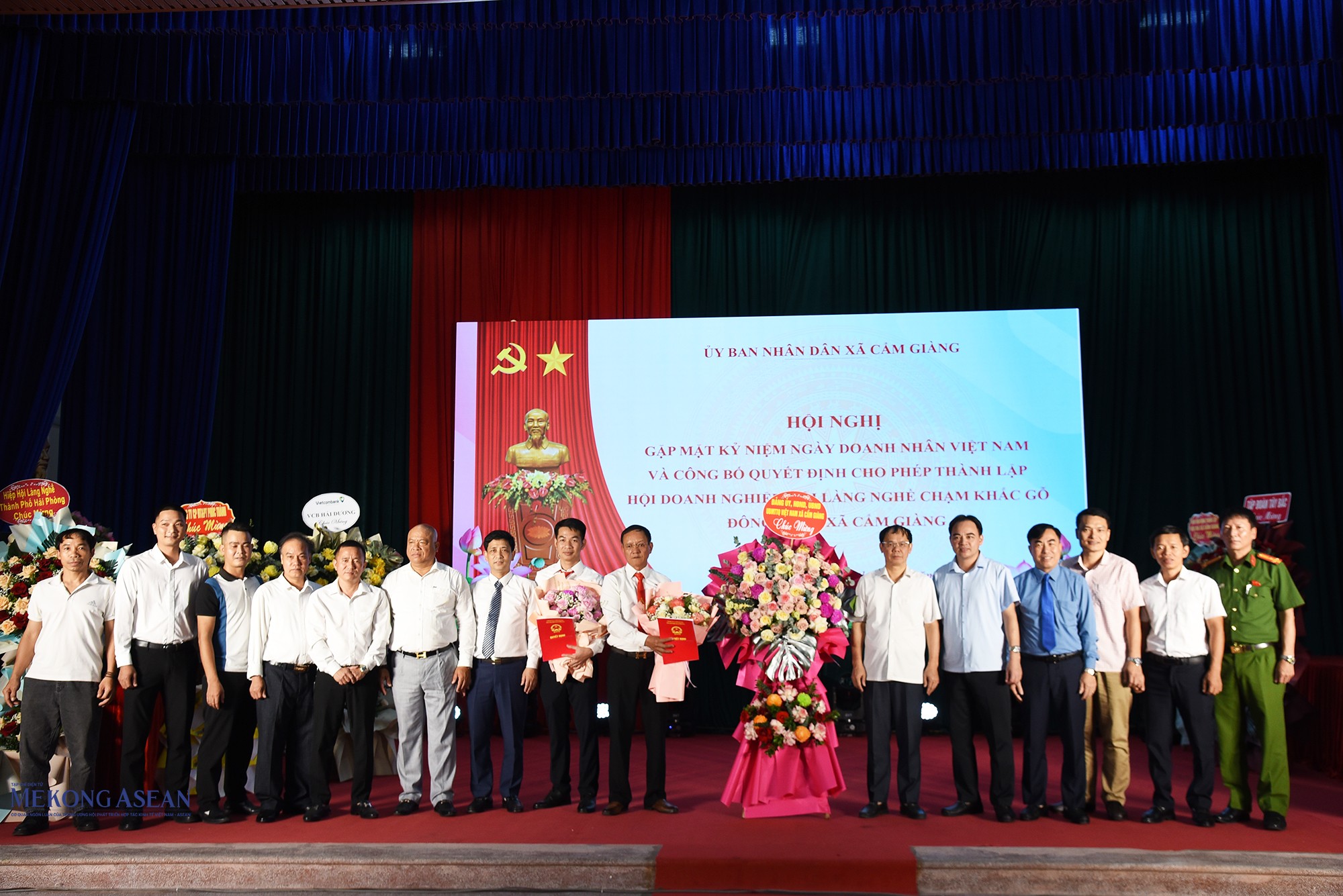 Lãnh đạo xã Cẩm Giàng tặng hoa chúc mừng Hội Doanh nghiệp và Hội làng nghề chạm khắc gỗ Đông Giao, xã Cẩm Giàng (thành phố Hải Phòng). Ảnh: Phùng Nguyện.
