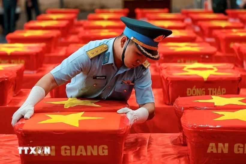 Cán bộ Quân chủng Phòng không Không quân sắp xếp các thùng chứa mẫu sinh phẩm hài cốt liệt sỹ tại khu vực tập kết, chuẩn bị bàn giao cho Viện Pháp y Quân đội phục vụ giám định ADN. Ảnh: TTXVN.