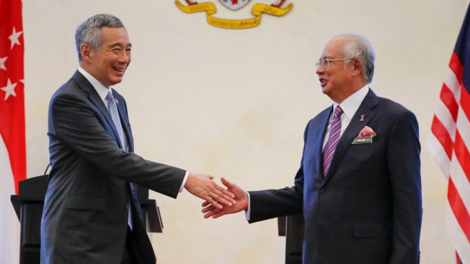 Thủ tướng Singapore L&yacute; Hiển Long (tr&aacute;i) bắt tay với Thủ tướng Malaysia Najib Razak tại Putrajaya, Malaysia, sau khi hai nước k&yacute; thỏa thuận về dự &aacute;n Đường sắt cao tốc Kuala Lumpur - Singapore (HSR) v&agrave;o th&aacute;ng 12/2016. Ảnh: AP