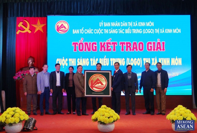 &Ocirc;ng Trương Đức San, Ph&oacute; B&iacute; thư Thị ủy, Chủ tịch UBND thị x&atilde; Kinh M&ocirc;n trao mẫu biểu trưng cho c&aacute;c phường, x&atilde; của thị x&atilde;.