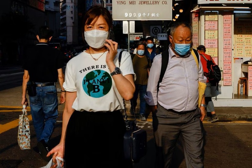 Người d&acirc;n Hong Kong đeo khẩu trang khi đi tr&ecirc;n đường phố. Ảnh: Reuters