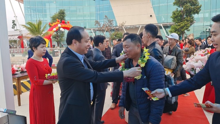 Chủ tịch UBND huyện V&acirc;n Đồn Vũ Đức Hưởng tặng hoa những h&agrave;nh kh&aacute;ch đầu ti&ecirc;n x&ocirc;ng cảng.