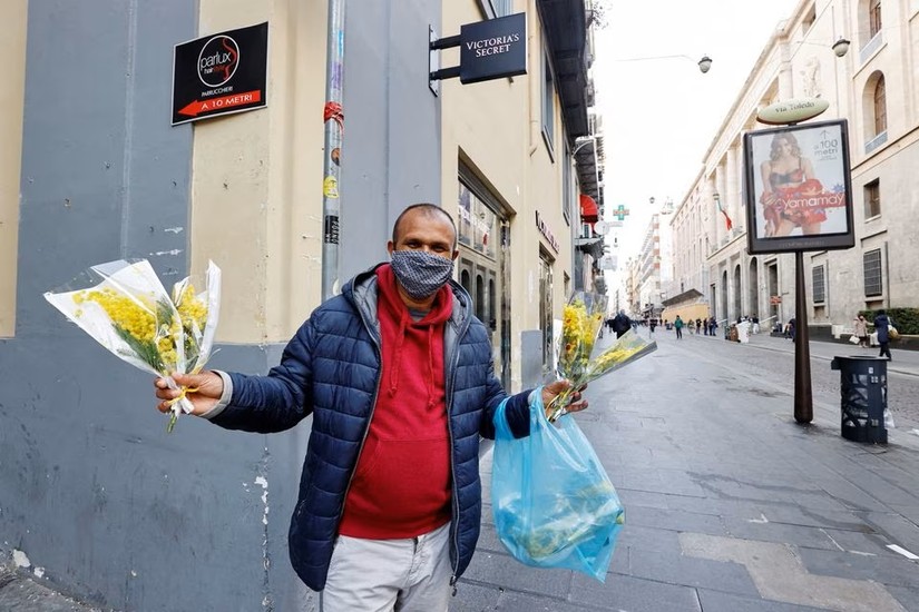 Một người b&aacute;n hoa tr&ecirc;n đường phố Naples, Italy, ng&agrave;y 8/3/2021. Ảnh: Reuters