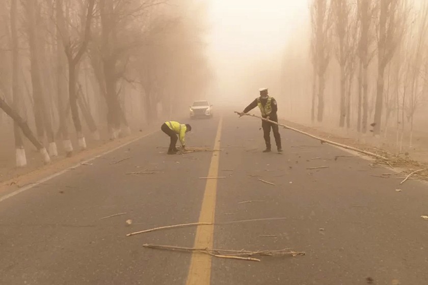 Cảnh s&aacute;t giao th&ocirc;ng tại Aksu, T&acirc;n Cương dọn dẹp đường giao th&ocirc;ng sau khi b&atilde;o c&aacute;t v&agrave; gi&oacute; mạnh tấn c&ocirc;ng th&agrave;nh phố. Ảnh: C&ocirc;ng an Aksu