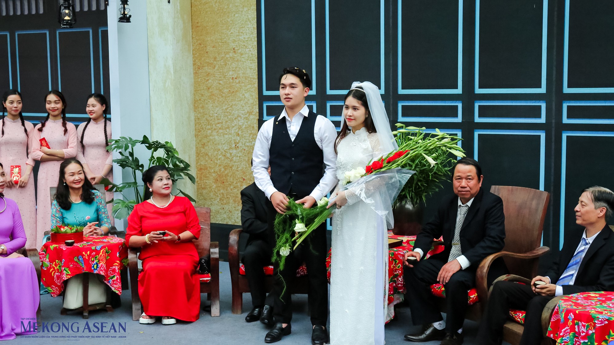 H&igrave;nh ảnh c&ocirc; d&acirc;u, ch&uacute; rể ra mắt 2 b&ecirc;n gia đ&igrave;nh với điểm nhấn l&agrave; chiếc &aacute;o d&agrave;i c&aacute;ch điệu, v&agrave; khăn voan v&agrave; b&oacute; hoa lay ơn tr&ecirc;n tay như một h&igrave;nh ảnh kinh điển trong lễ cưới 40 năm về trước.