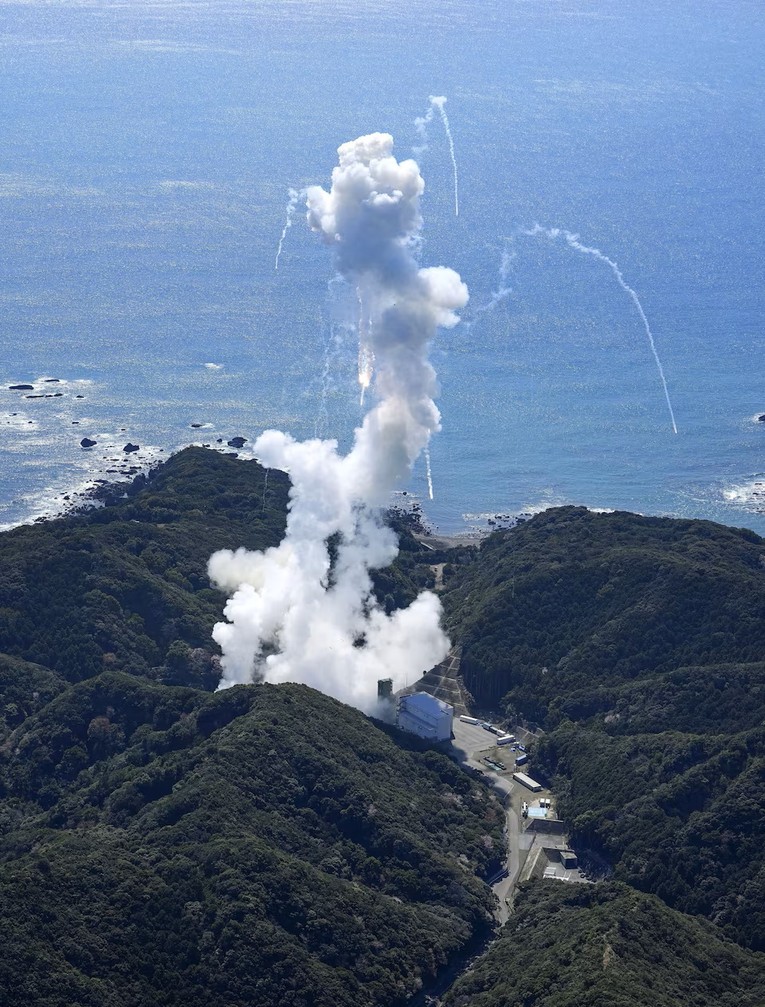 Kh&oacute;i bốc l&ecirc;n v&agrave; c&aacute;c mảnh vỡ t&ecirc;n lửa rơi xuống. Ảnh: Kyodo News