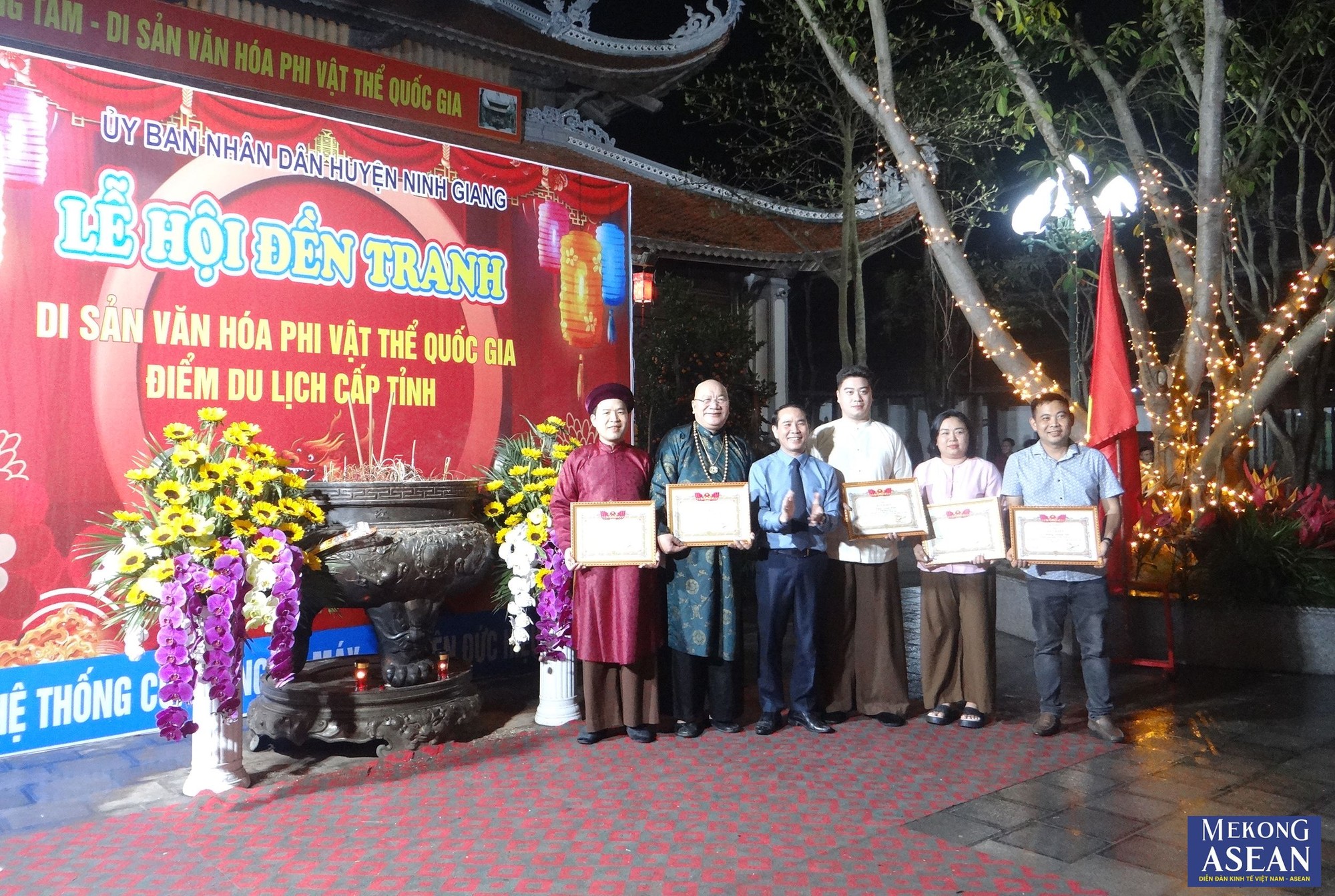 Đại diện Ban tổ chức lễ hội tặng Giấy khen cho c&aacute;c thanh đồng tham gia tr&igrave;nh diễn h&aacute;t văn tại đền Tranh, tối 18/3.