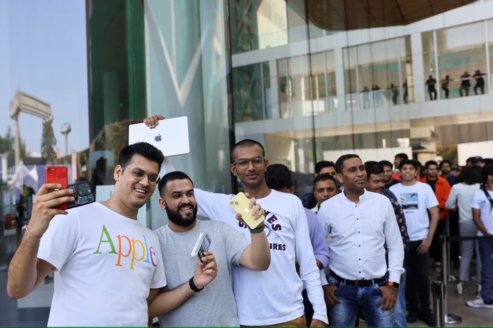 H&agrave;ng d&agrave;i người h&acirc;m mộ cầm theo c&aacute;c sản phẩm của Apple v&agrave; xếp h&agrave;ng b&ecirc;n ngo&agrave;i cửa h&agrave;ng. Ảnh: Reuters