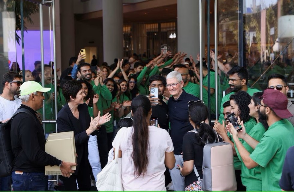 Người h&acirc;m mộ chụp h&igrave;nh với &ocirc;ng Tim Cook tại ng&agrave;y khai trương cửa h&agrave;ng. Ảnh: Reuters