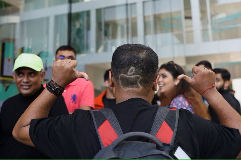 Người h&acirc;m mộ cắt t&oacute;c theo h&igrave;nh logo Apple. Ảnh: Reuters