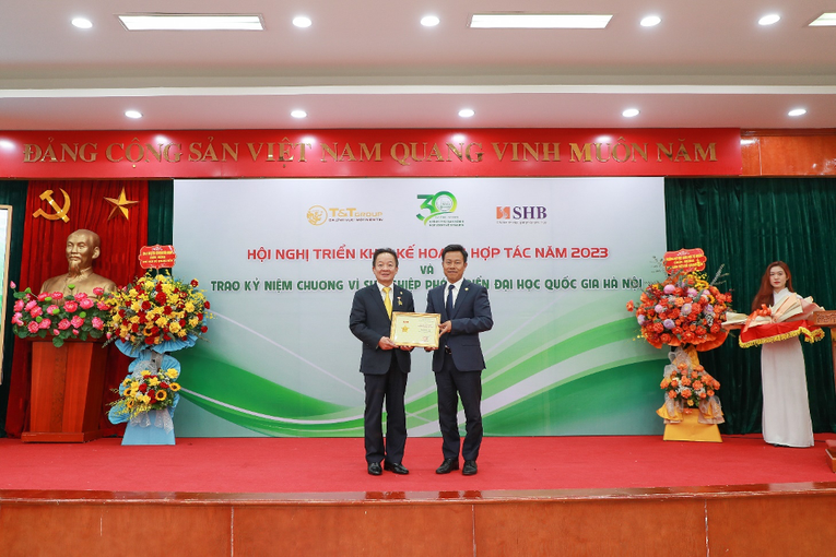 GS.TS L&ecirc; Qu&acirc;n (b&ecirc;n phải) trao kỷ niệm chương v&igrave; sự nghiệp ph&aacute;t triển ĐHQGHN cho doanh nh&acirc;n Đỗ Quang Hiển.
