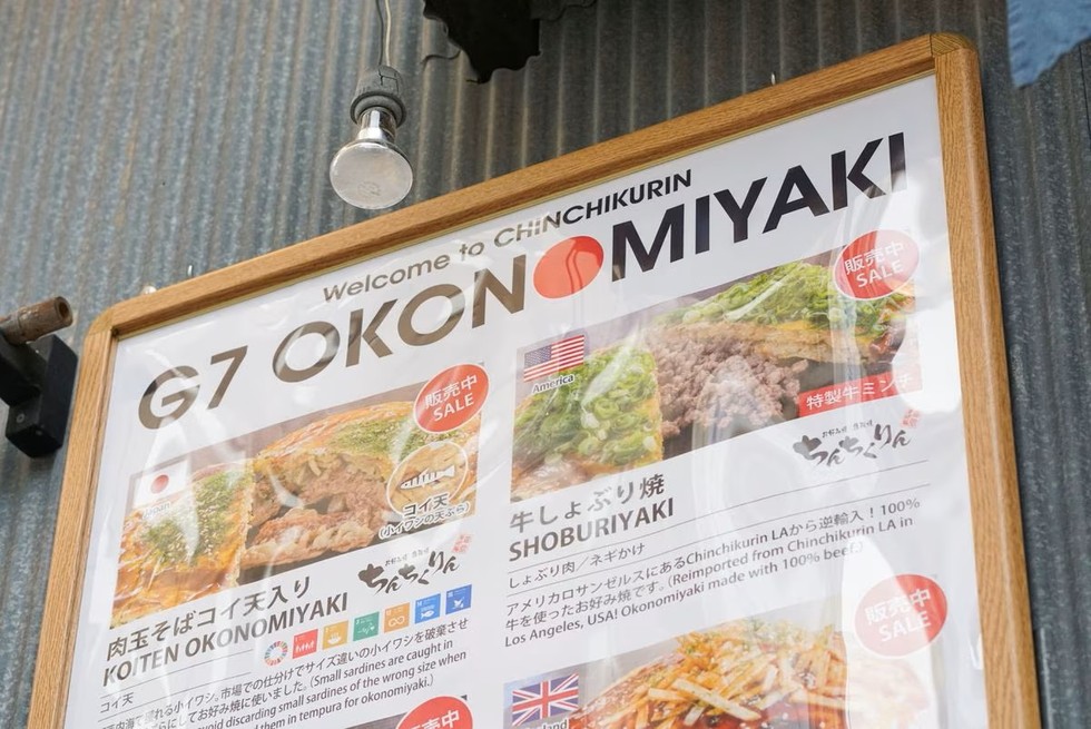 Thực đơn đa ng&ocirc;n ngữ với c&aacute;c phi&ecirc;n bản okonomiyaki kh&aacute;c nhau chuẩn bị cho thực kh&aacute;ch tới tham gia hội nghị G7 tại nh&agrave; h&agrave;ng Chinchikurin tại Hiroshima. Ảnh: Reuters