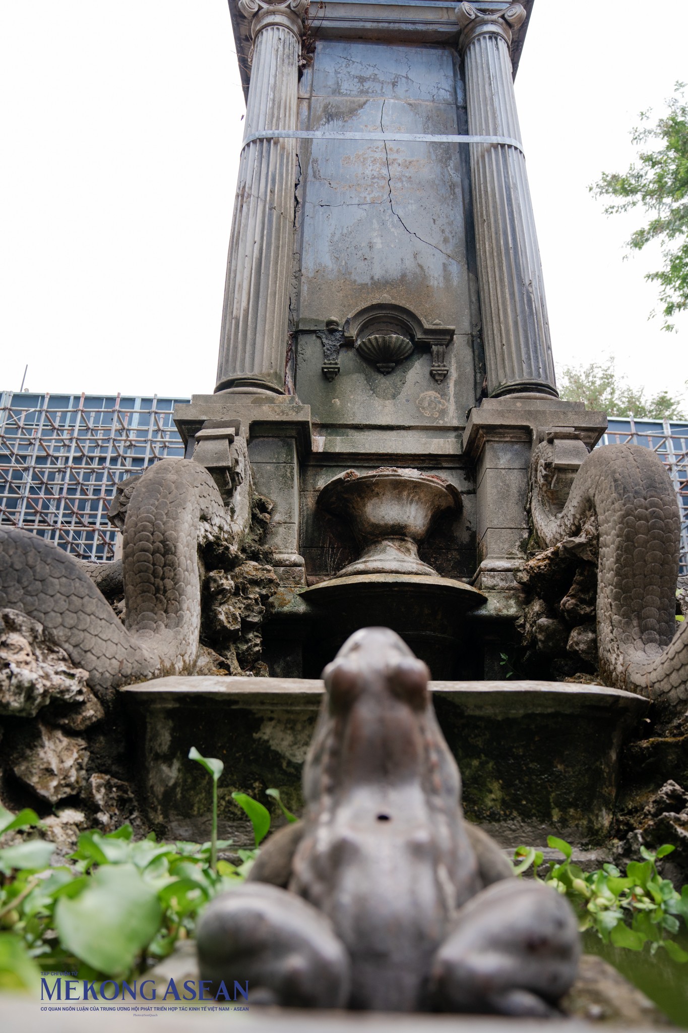 Nằm giữa vườn hoa l&agrave; đ&agrave;i phun nước h&igrave;nh tr&ograve;n bao bọc lấy trụ đ&aacute; to h&igrave;nh vu&ocirc;ng cao khoảng 3,5m. C&ocirc;ng tr&igrave;nh đ&agrave;i tưởng niệm n&agrave;y được phỏng theo lối Roman, sử dụng thức cột Ionic điển h&igrave;nh. Điều dễ nhận biết nhất của thức cột đỡ trụ đ&aacute; đ&agrave;i tưởng niệm l&agrave; đầu cột c&oacute; hai v&ograve;m xoắn ốc. C&aacute;c đường gờ ph&agrave;o chỉ chạy dọc th&acirc;n cột l&agrave; hiện th&acirc;n của thức cột Doric.