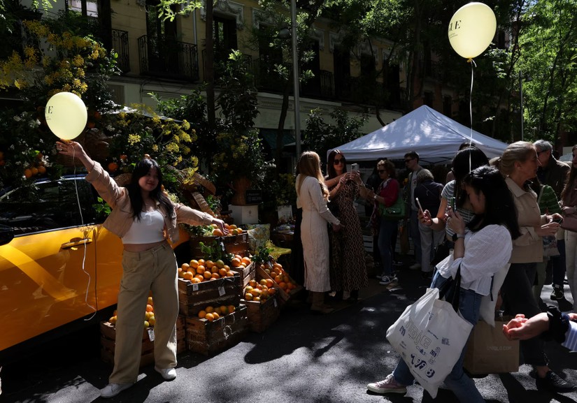 Du kh&aacute;ch Trung Quốc chụp ảnh tại phi&ecirc;n chợ ngo&agrave;i trời ở th&agrave;nh phố Salamanca, Madrid, T&acirc;y Ban Nha. Ảnh: Reuters