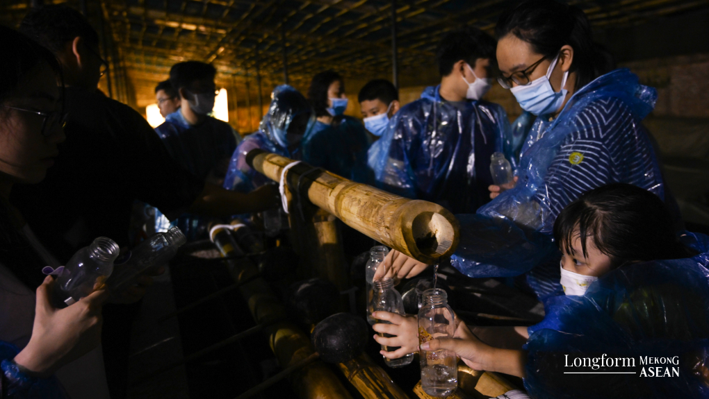 Kh&aacute;ch tham quan lấy nước giếng ngọc về l&agrave;m qu&agrave; lưu niệm.