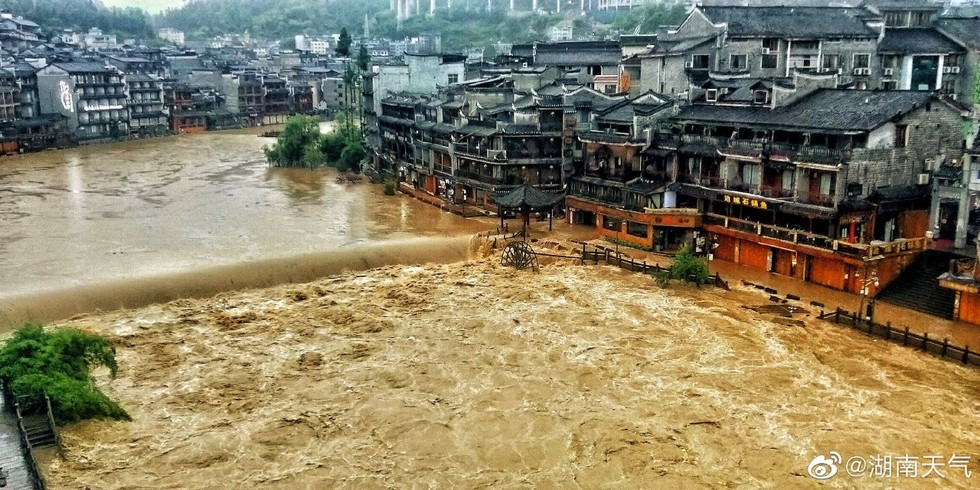 Nhiều hộ kinh doanh phải d&ugrave;ng v&aacute;n gỗ ngăn kh&ocirc;ng cho nước v&agrave;o nh&agrave;. Ảnh: Weibo Thời tiết Hồ Nam