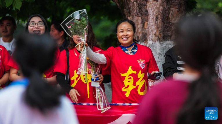 Gi&aacute;o vi&ecirc;n mặc &aacute;o m&agrave;u đỏ động vi&ecirc;n c&aacute;c th&iacute; sinh b&ecirc;n ngo&agrave;i địa điểm cao khảo ở Qu&yacute; Dương, tỉnh Qu&yacute; Ch&acirc;u ph&iacute;a t&acirc;y nam Trung Quốc ng&agrave;y 7/6/2024. Ảnh: T&acirc;n Hoa X&atilde;