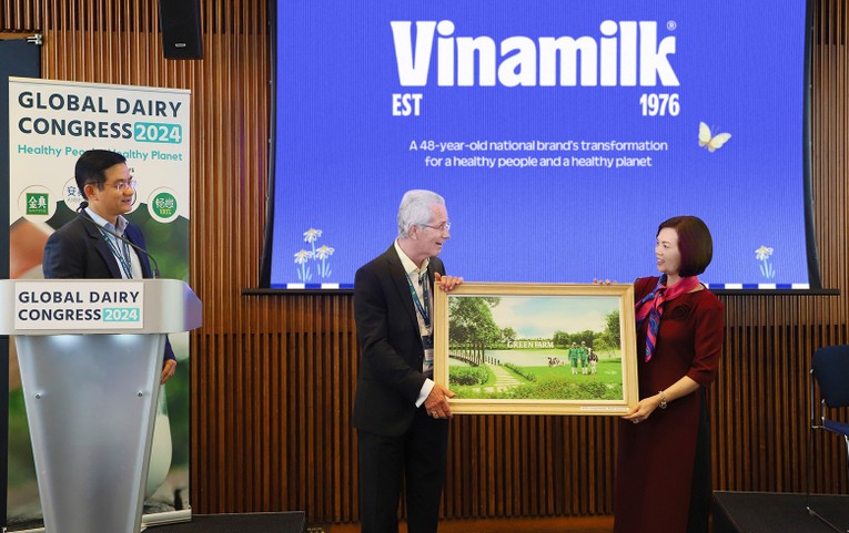 Đại diện Vinamilk trao tặng bức tranh trang trại Green Farm của Vinamilk đến chủ tịch hội nghị sữa to&agrave;n cầu - &ocirc;ng Richard Hall (b&ecirc;n tr&aacute;i).