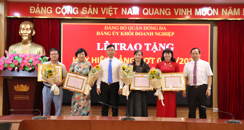 B&iacute; thư Đảng ủy Khối Doanh nghiệp Vũ Mạnh Chiến (thứ 3 từ tr&aacute;i sang) v&agrave; Ph&oacute; B&iacute; thư Đảng ủy Khối Nguyễn Văn Quang (ngo&agrave;i c&ugrave;ng b&ecirc;n phải) trao Huy hiệu Đảng cho c&aacute;c Đảng vi&ecirc;n l&atilde;o th&agrave;nh đợt 2/9. Ảnh: Phương Thảo.