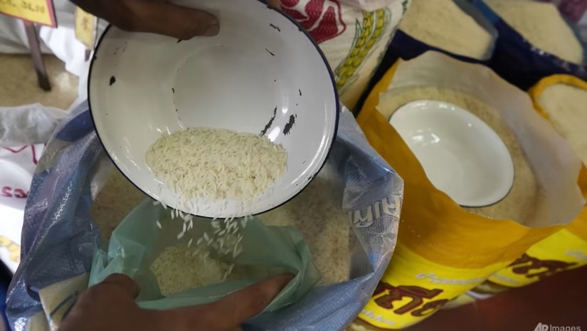 Một c&ocirc;ng nh&acirc;n m&uacute;c gạo cho v&agrave;o bao đựng, ng&agrave;y 10/8. Ảnh: AP