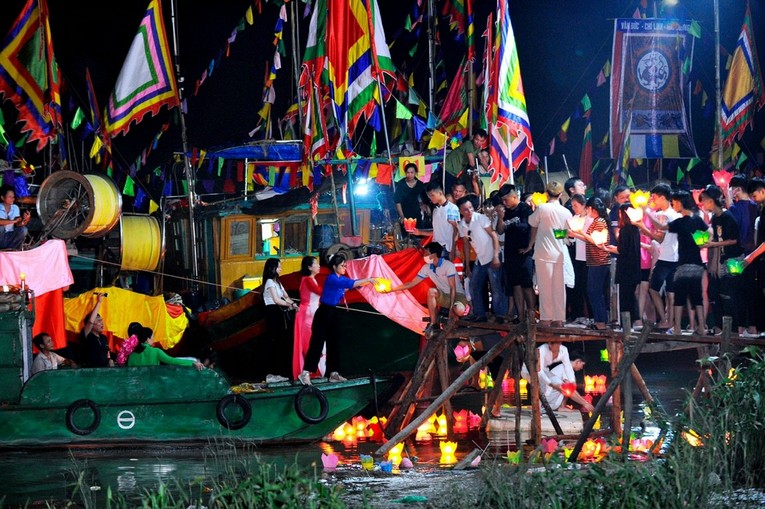 Những b&ocirc;ng hoa đăng được mọi người truyền tay nhau thả xuống d&ograve;ng s&ocirc;ng Lục Đầu