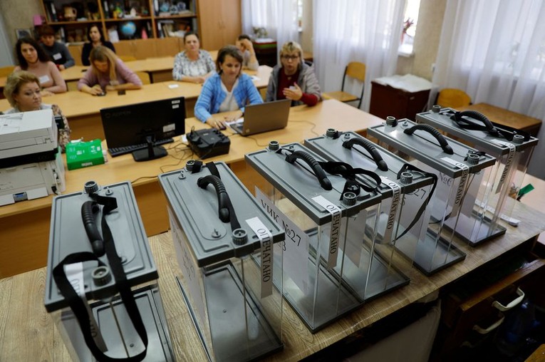 C&aacute;c th&agrave;nh vi&ecirc;n của Ủy ban bầu cử tập trung tại một điểm bỏ phiếu ở tỉnh Donetsk. Ảnh: Reuters
