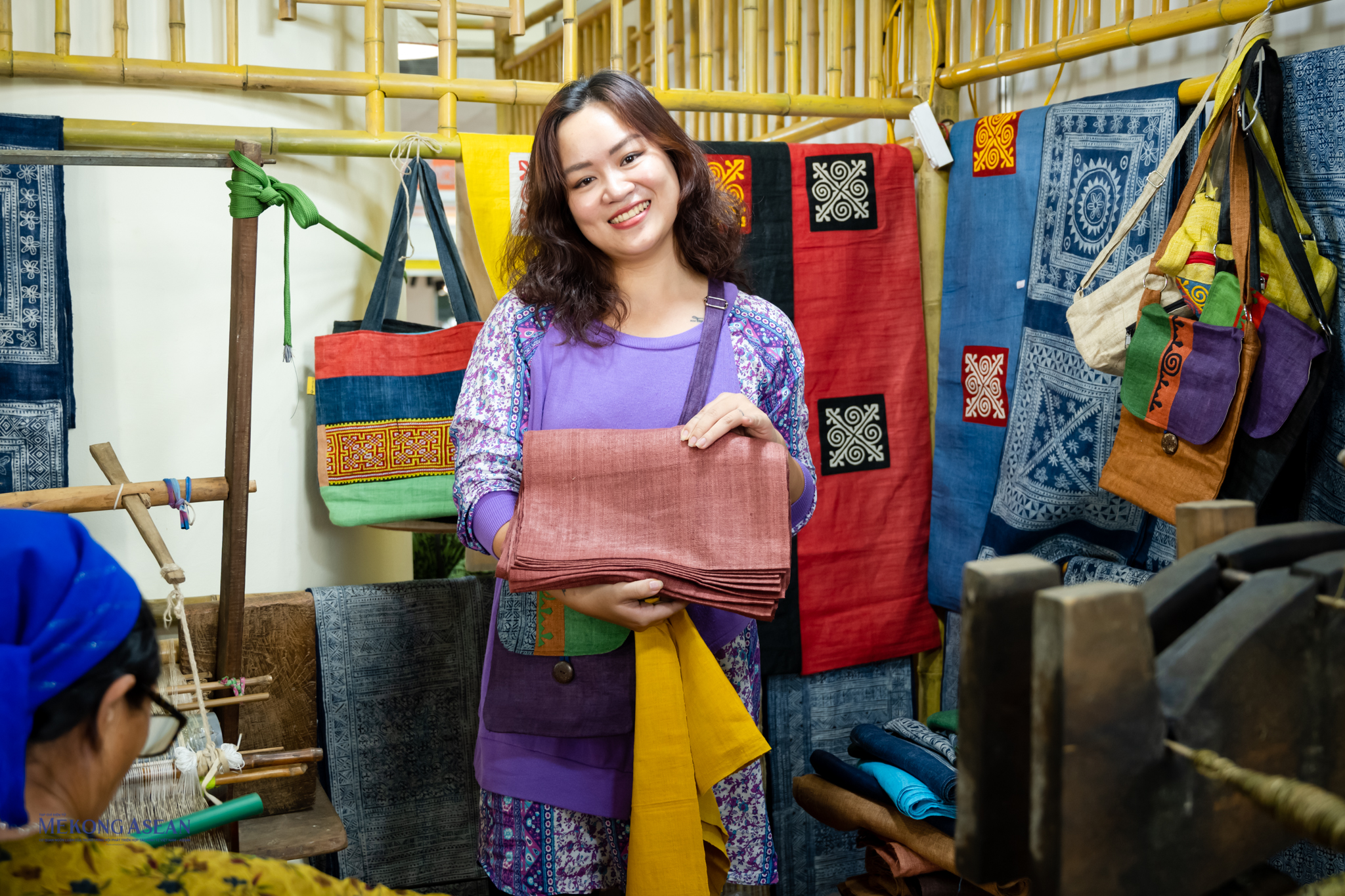 Du kh&aacute;ch tới thăm quan rất th&iacute;ch th&uacute; với nghề dệt vải thủ c&ocirc;ng tại hội chợ.