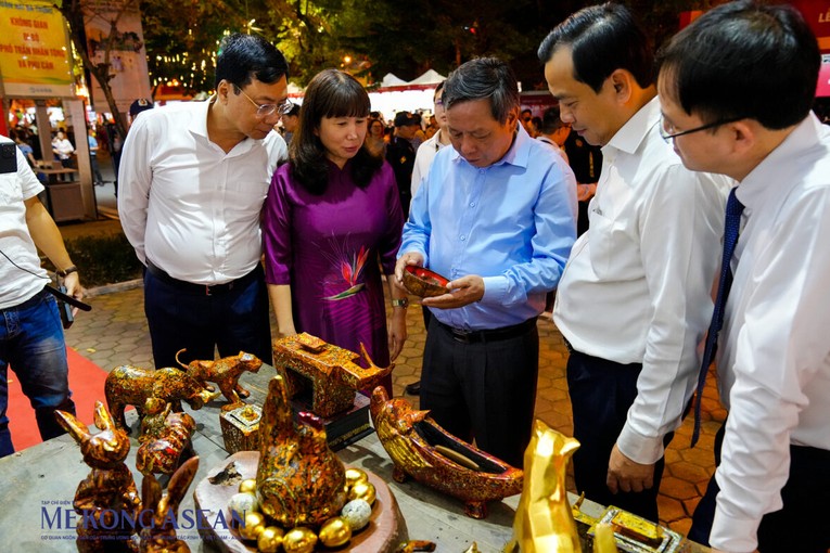 C&aacute;c đại biểu tham quan gian h&agrave;ng c&aacute;c sản phẩm sơn m&agrave;i của nghệ nh&acirc;n Nguyễn Tấn Ph&aacute;t (l&agrave;ng cổ Đường L&acirc;m, thị x&atilde; Sơn T&acirc;y). Ảnh: Thảo Ng&acirc;n.