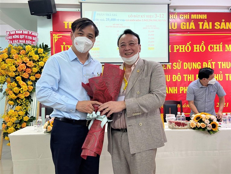 Ph&oacute; Chủ tịch UBND TPHCM L&ecirc; H&ograve;a B&igrave;nh trao hoa ch&uacute;c mừng &ocirc;ng Đỗ Anh Dũng đ&atilde; đấu gi&aacute; th&agrave;nh c&ocirc;ng l&ocirc; đất k&yacute; hiệu 3-12 tại Khu đ&ocirc; thị mới Thủ Thi&ecirc;m.