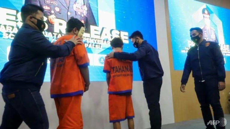 Hai tin tặc bị bắt giữ v&igrave; li&ecirc;n quan đến một vụ lừa đảo 60 triệu USD tiền hỗ trợ Covid-19 tại Indonesia. Ảnh: AFP